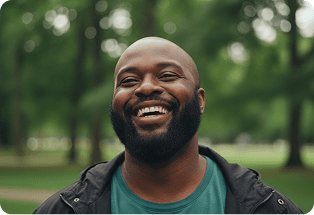 Smiling bearded man outdoors among trees
